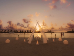 Candlelit beach dinner setup at Villa Nautica at sunset, with lanterns, soft lighting and the ocean in the background