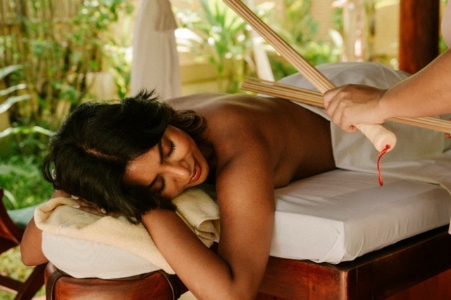 Guest experiencing bamboo brooming during the Voyager treatment at Araamu Spa at Villa Park in the Maldives