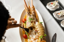 Hook restaurant at Villa Nautica Maldives with lobster, oysters and grilled seafood on a white linen table