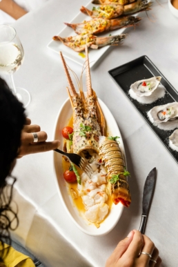 Hook restaurant at Villa Nautica Maldives with lobster, oysters and grilled seafood on a white linen table
