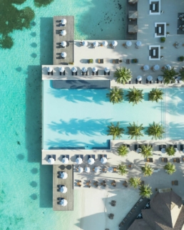 Aerial view of the main pool, beachfront seating and lagoon at Villa Nautica Maldives in North Mal&eacute; Atoll