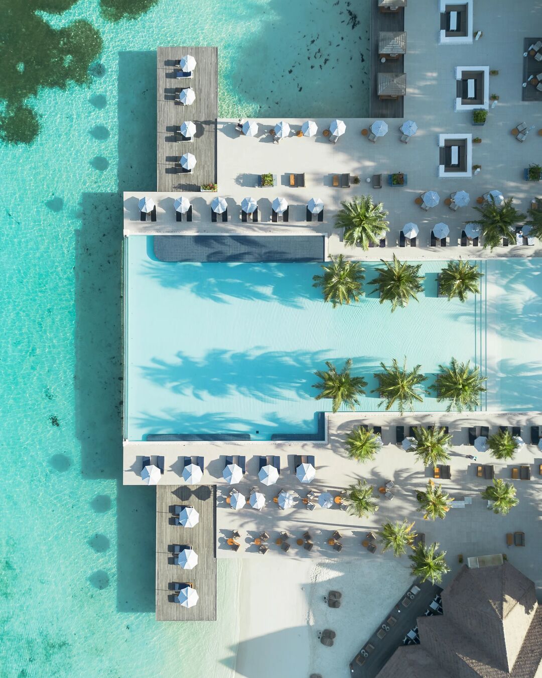 Aerial view of the main pool, beachfront seating and lagoon at Villa Nautica Maldives in North Malé Atoll