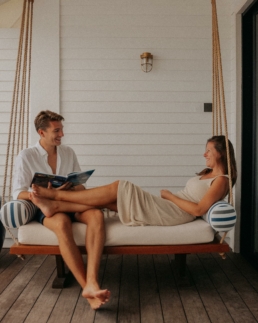 Couple relaxing on a daybed outside a Deluxe Beach Pool Villa at Villa Nautica Maldives