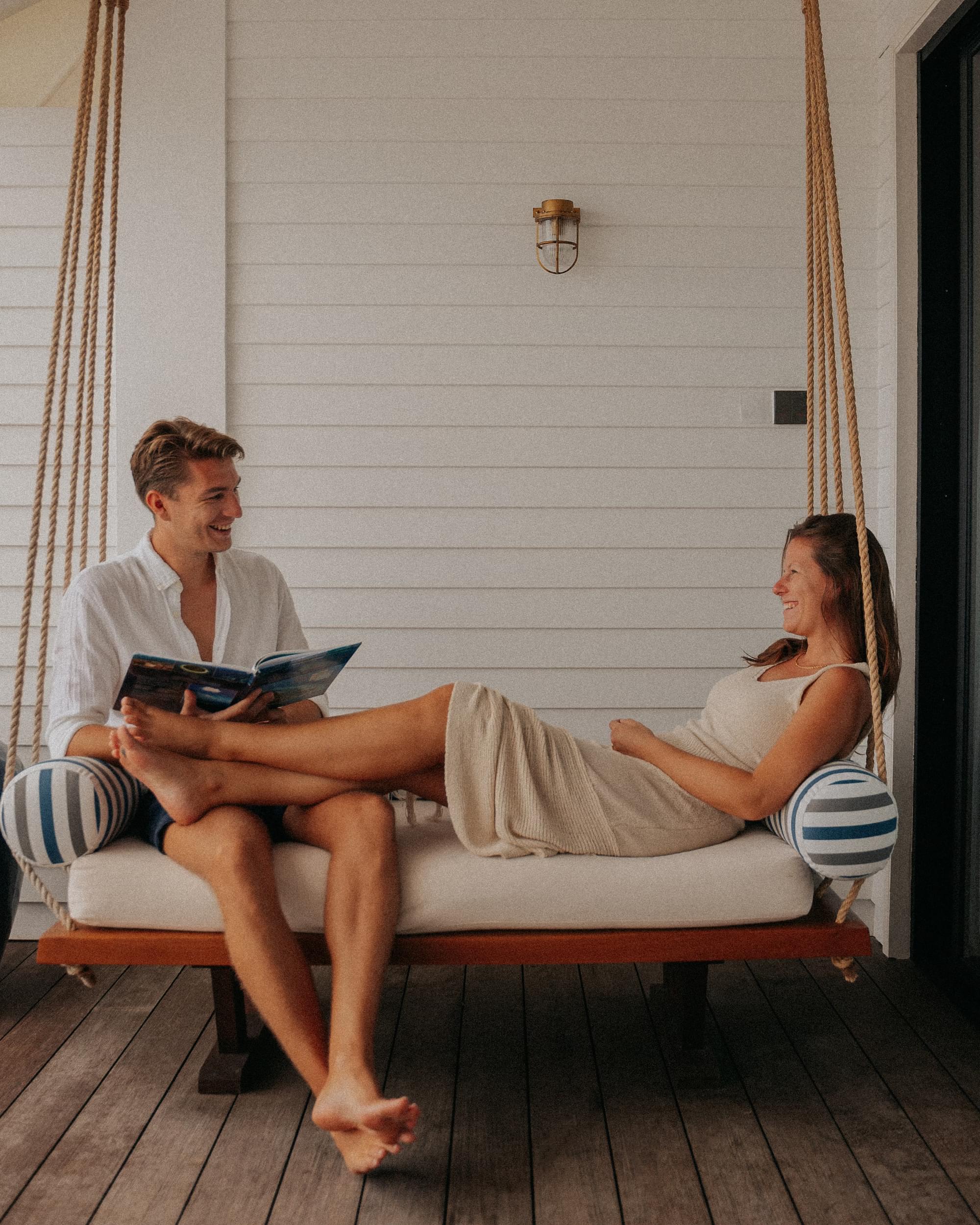 Couple relaxing on a daybed outside a Deluxe Beach Pool Villa at Villa Nautica Maldives