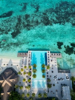 Aerial view of Villa Nautica’s infinity pool overlooking the turquoise lagoon in North Malé Atoll.