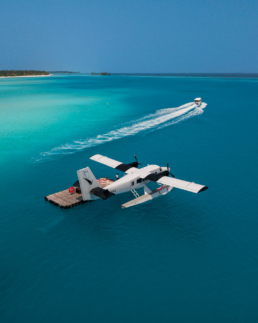 Aerial side view of a Villa Air Maldives seaplane above deep blue Maldivian waters near Villa Park