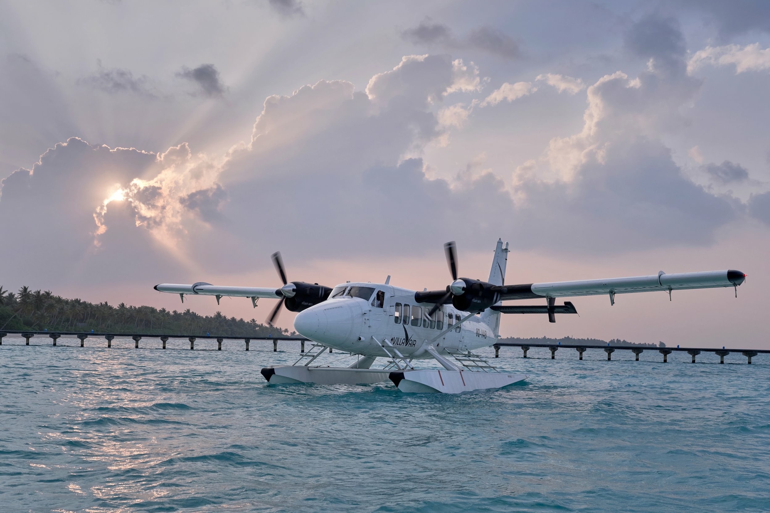 Villa Air Maldives seaplane beside a floating platform under a bright sky near Villa Park