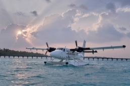 Villa Air Maldives seaplane beside a floating platform under a bright sky near Villa Park